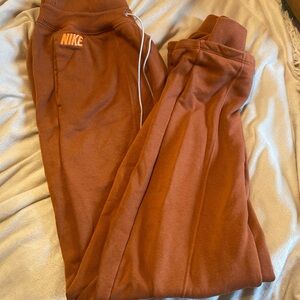 Orange Nike track sweatpants with drawstring